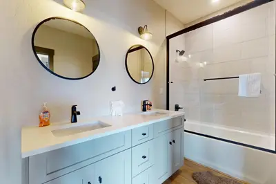a bathroom with two sinks and a shower with mirrors at Mountain Bliss Retreat in Granby in Granby