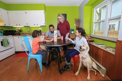 a group of people sitting around a table in a kitchen with a dog at Remington Flats in Fort Collins