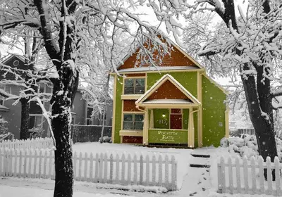 a house covered in snow in front of a fence at Remington Flats in Fort Collins