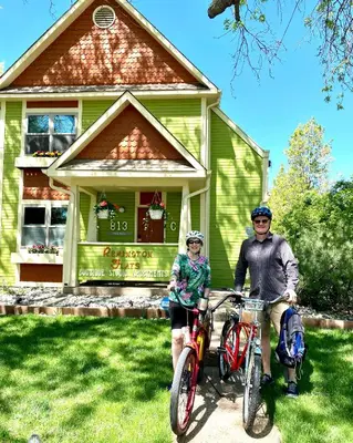 a man and woman on bikes in front of a house at Remington Flats in Fort Collins