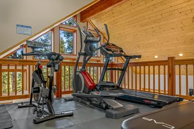 two exercise bikes in a gym with wooden walls at Tranquil Trails in Granby