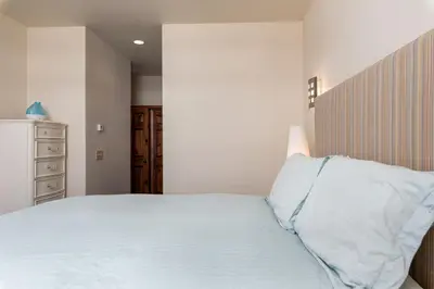 a bedroom with a white bed with a wooden headboard at Wonderful Mountain Retreat with Fantastic Views in Fraser