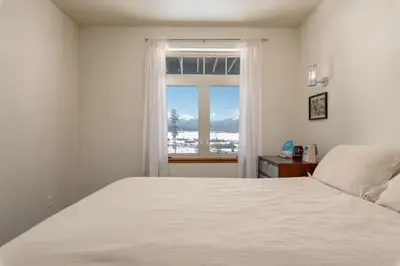 a bedroom with a white bed and a window at Wonderful Mountain Retreat with Fantastic Views in Fraser