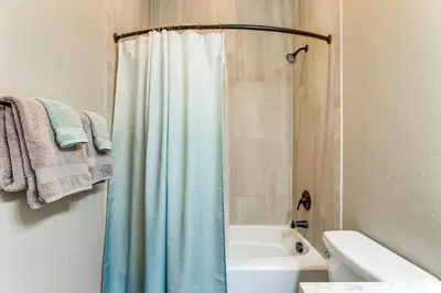 a bathroom with a shower with a blue shower curtain at 5 Mi to Winter Park Resort Fraser Family Home in Fraser