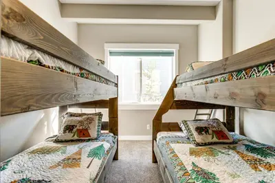 two bunk beds in a room with a window at 5 Mi to Winter Park Resort Fraser Family Home in Fraser