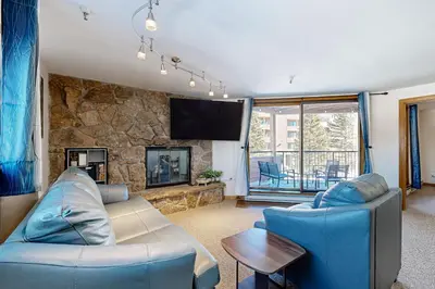 a living room with blue furniture and a stone wall at Mountain View Lakeside Retreat in Dillon