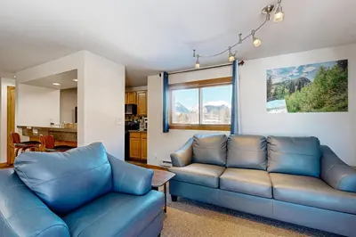 a living room with a blue couch and a table at Mountain View Lakeside Retreat in Dillon