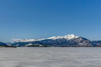 a snow covered mountain in the middle of a body of water at Mountain View Lakeside Retreat in Dillon