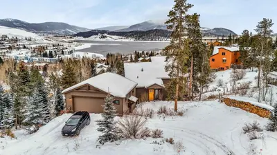 a car parked in front of a house in the snow at Dillon Retreat with Lake Views and Private Hot Tub in Dillon
