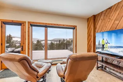 a living room with two chairs and a large window at Dillon Retreat with Lake Views and Private Hot Tub in Dillon
