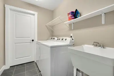 a white bathroom with a sink and a white door at Old Town Escape with King Bed, Dog-Friendly in Fort Collins