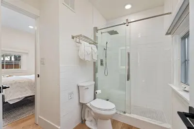 a white bathroom with a toilet and a shower at Chic Luxury Retreat in Old Town, Walk Everywhere! in Fort Collins