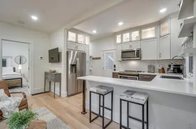 a kitchen with white cabinets and a living room at Chic Luxury Retreat in Old Town, Walk Everywhere! in Fort Collins
