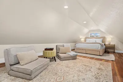 a bedroom with a bed and a couch and a chair at Chic Luxury Retreat in Old Town, Walk Everywhere! in Fort Collins