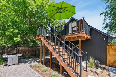 a tree house with a staircase and an umbrella at Chic Luxury Retreat in Old Town, Walk Everywhere! in Fort Collins
