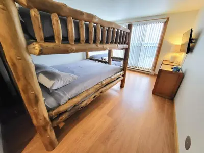 a bedroom with two bunk beds and a wooden floor at Best Location in Downtown Winter Park in Winter Park
