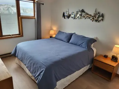 a bedroom with a bed with blue sheets and a window at Best Location in Downtown Winter Park in Winter Park