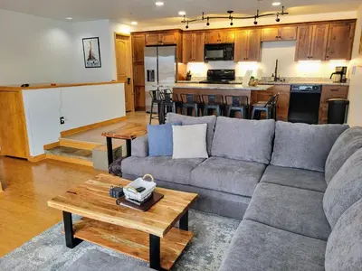 a living room with a couch and a kitchen at Best Location in Downtown Winter Park in Winter Park