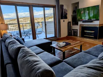 a living room with a large couch and a tv at Best Location in Downtown Winter Park in Winter Park