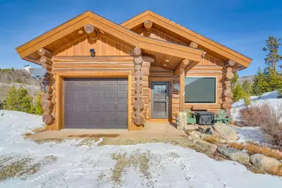 a log house with a garage in the snow at Close to RMNP and Beach Grand Lake Cabin Retreat! in Grand Lake