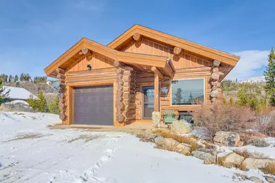 a log house with a garage in the snow at Close to RMNP and Beach Grand Lake Cabin Retreat! in Grand Lake