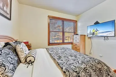 a bedroom with a bed and a flat screen tv at Cozy 3BR Keystone Escape with Fireplace and Hot Tub in Keystone
