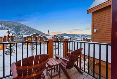 a balcony with a table and chairs and snow covered mountains at Cozy 3BR Keystone Escape with Fireplace and Hot Tub in Keystone