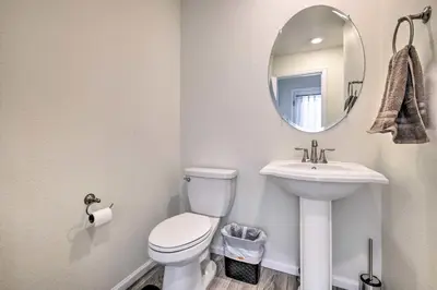 a bathroom with a toilet and a sink and a mirror at Charming 3BR Retreat - Perfect for Families! in Fort Collins