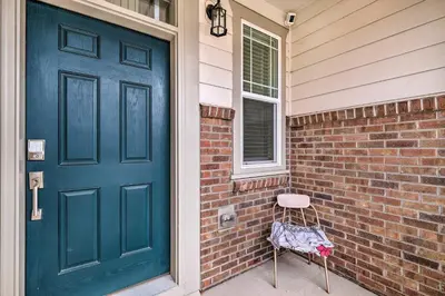a blue door with a chair next to a brick house at Charming 3BR Retreat - Perfect for Families! in Fort Collins