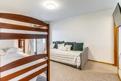 a bedroom with a bunk bed and a couch at 5 Mi to Winter Park Resort Unit with Pool and Hot Tub in Fraser