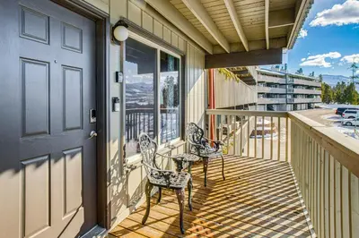 a porch with two chairs and a table on a balcony at 5 Mi to Winter Park Resort Unit with Pool and Hot Tub in Fraser