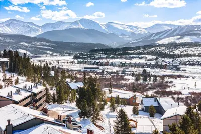 a town covered in snow with mountains in the background at 5 Mi to Winter Park Resort Unit with Pool and Hot Tub in Fraser