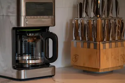 a coffee maker on a counter next to a knife block at Luxurious Chalet - Epic Views, Hot Tub, Gym, Game Room, & 4k Projector in Grand Lake in Grand Lake