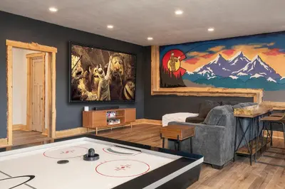 a living room with a large painting on the wall at Luxurious Chalet - Epic Views, Hot Tub, Gym, Game Room, & 4k Projector in Grand Lake in Grand Lake