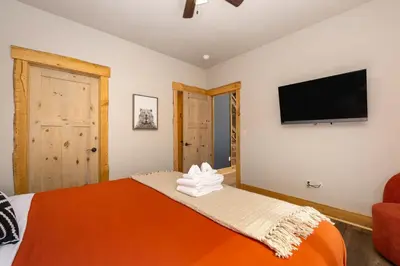 a bedroom with a bed and a flat screen tv at Luxurious Chalet - Epic Views, Hot Tub, Gym, Game Room, & 4k Projector in Grand Lake in Grand Lake