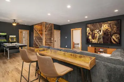 a living room with a couch and a ping pong table at Luxurious Chalet - Epic Views, Hot Tub, Gym, Game Room, & 4k Projector in Grand Lake in Grand Lake