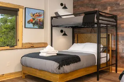a bedroom with a bunk bed and a window at Luxurious Chalet - Epic Views, Hot Tub, Gym, Game Room, & 4k Projector in Grand Lake in Grand Lake