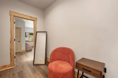 a living room with a chair and a mirror at Luxurious Chalet - Epic Views, Hot Tub, Gym, Game Room, & 4k Projector in Grand Lake in Grand Lake