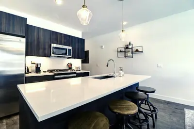 a kitchen with a white counter and stools at River West 611 condo in Silverthorne