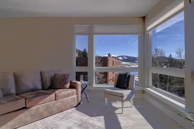 a living room with a couch and a chair and large windows at Sail Lofts 205 condo in Dillon