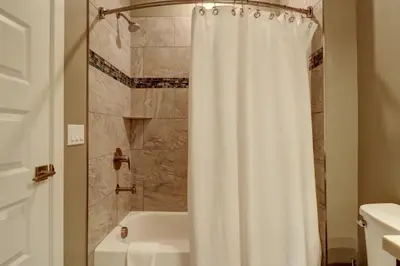a bathroom with a shower with a white shower curtain at Sail Lofts 205 condo in Dillon