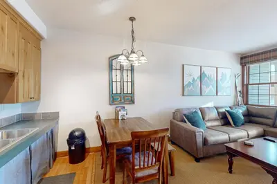 a kitchen and living room with a couch and a table at Horse Lodges 5-102 in Granby