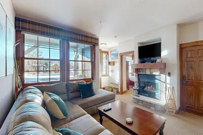 a living room with a couch and a fireplace at Horse Lodges 5-102 in Granby