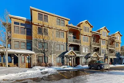 an apartment building with a car parked in front of it at Horse Lodges 5-102 in Granby