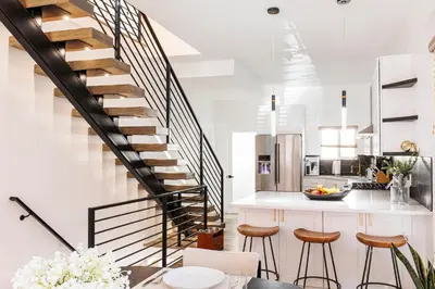 a staircase in a kitchen with stools and a counter at Lux Newly Remodeled DT, Patio, Fully Stocked 5Bd, 3Ba in Denver