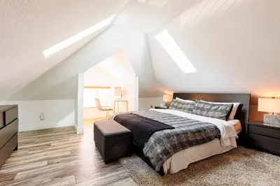 a bedroom with a large bed in a attic at Lux Newly Remodeled DT, Patio, Fully Stocked 5Bd, 3Ba in Denver