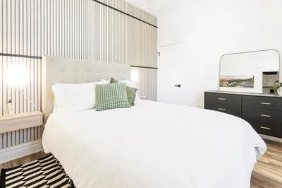 a white bedroom with a large bed and a mirror at Lux Newly Remodeled DT, Patio, Fully Stocked 5Bd, 3Ba in Denver