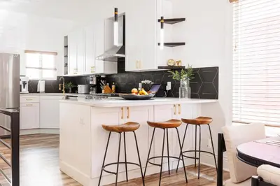 a kitchen with white cabinets and bar stools at Lux Newly Remodeled DT, Patio, Fully Stocked 5Bd, 3Ba in Denver