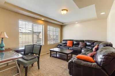 a living room with a leather couch and a table at 6 Mi to DIA Spacious Home with Backyard in Denver! in Aurora