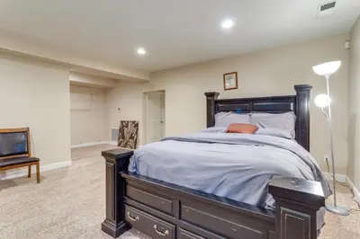 a bedroom with a large bed with a wooden frame at 6 Mi to DIA Spacious Home with Backyard in Denver! in Aurora